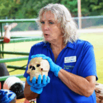 Joetta White showing a model of a skull in a farm building