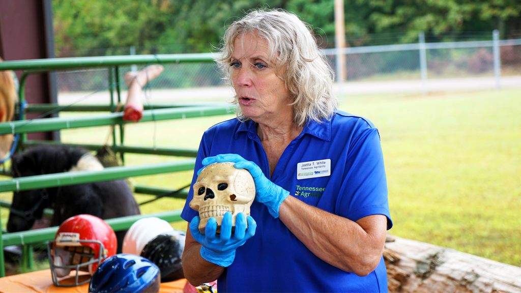 Joetta White showing a model of a skull in a farm building